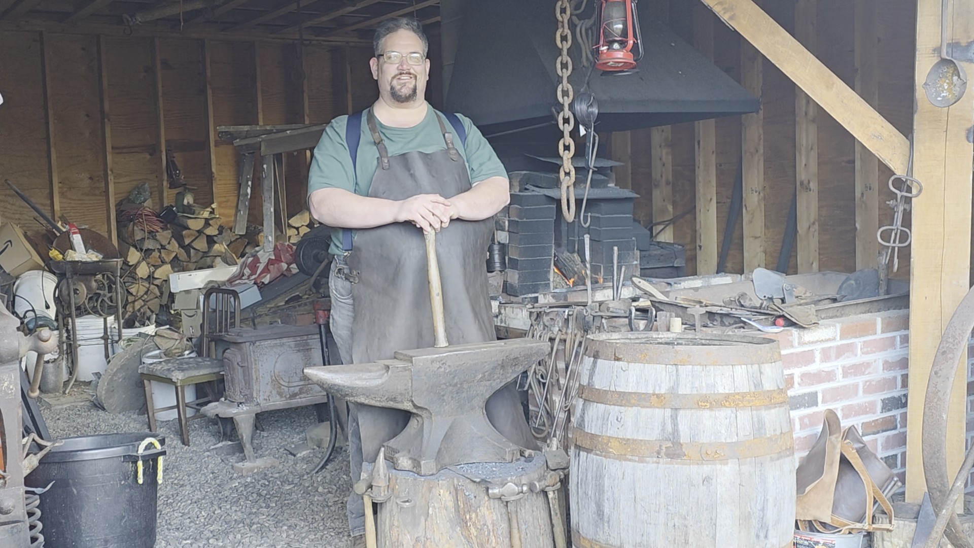 Sam H. Smith standing at the anvil in his working forge